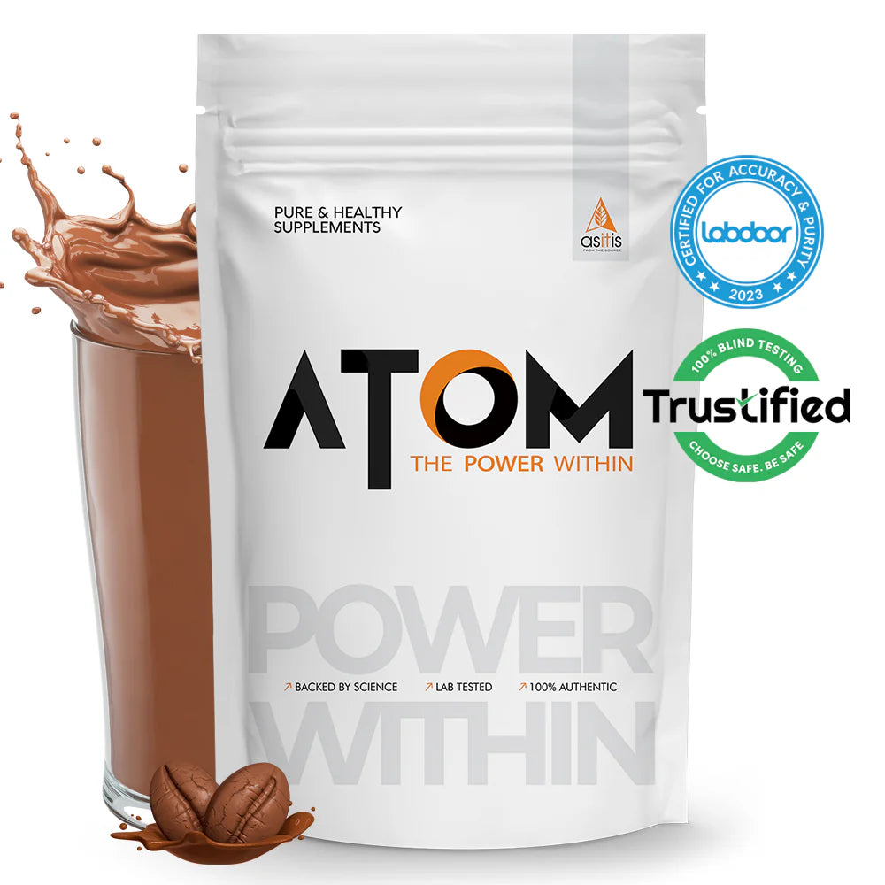 ATOM supplement package with a glass of chocolate shake and coffee beans on a white background