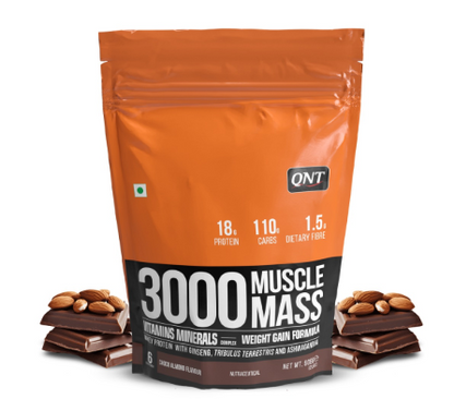 Orange and black package of QNT 3000 Muscle Mass supplement with chocolate bars and almonds on a white background