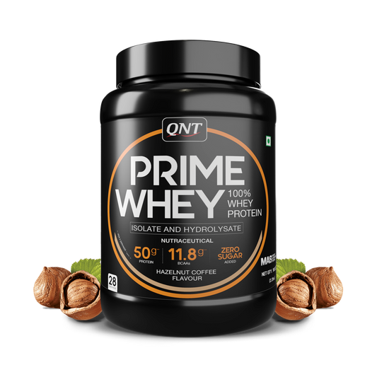 QNT Prime Whey protein powder container with hazelnuts on a white background